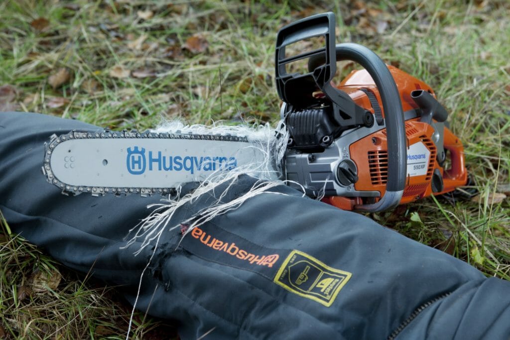A chainsaw chain entangled in the long fibres inside of a pair of protective trousers