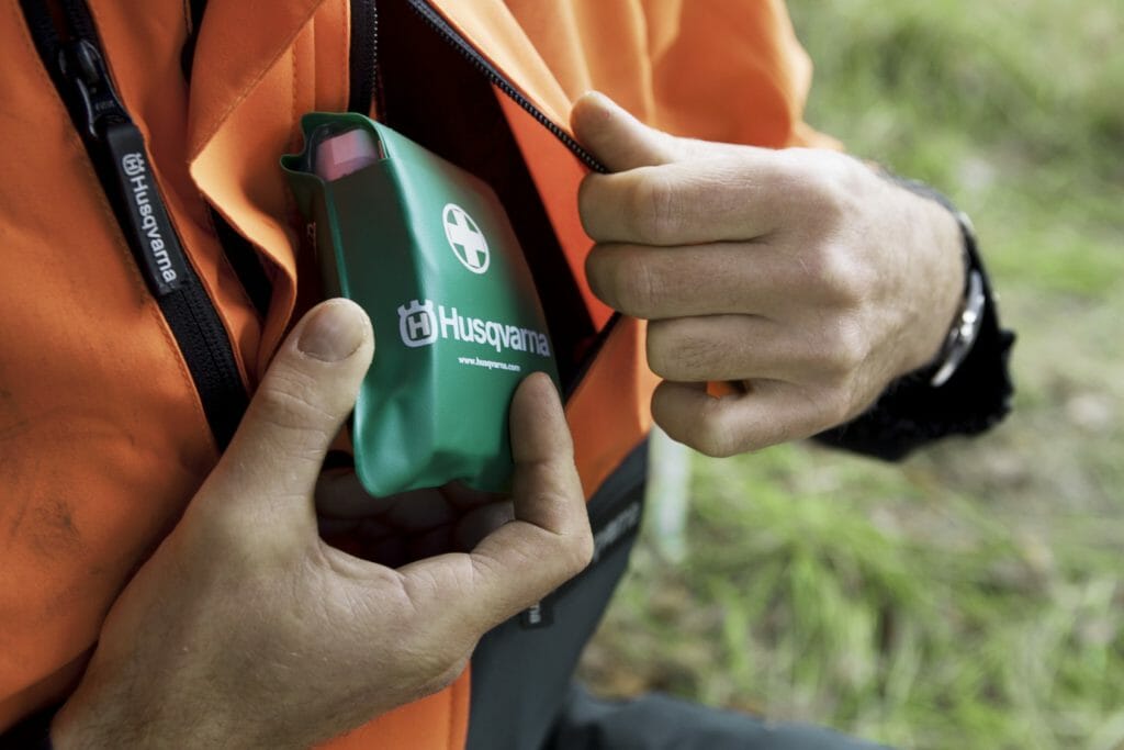 A first aid kit is put in a chest pocket of a forestry jacket