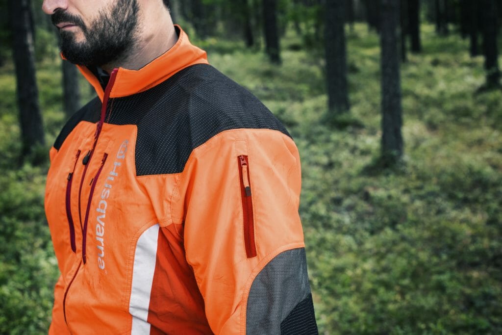 Forestry worker wearing a signal coloured forestry jacket with reflective fields