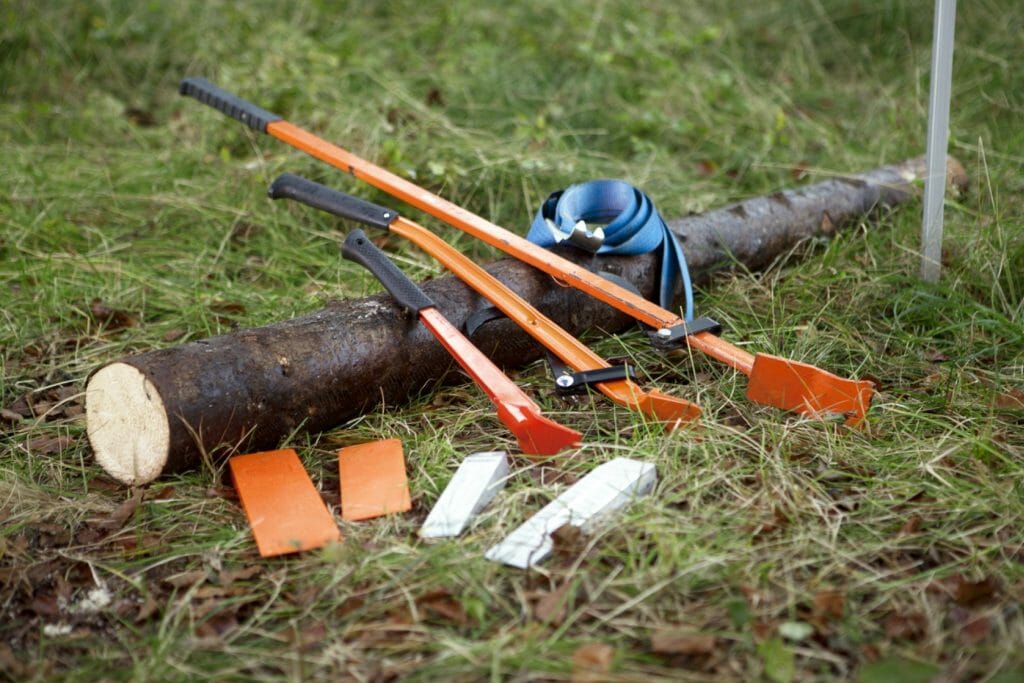 Breaking bars, wedges and a turning strap lying on a small log on the ground