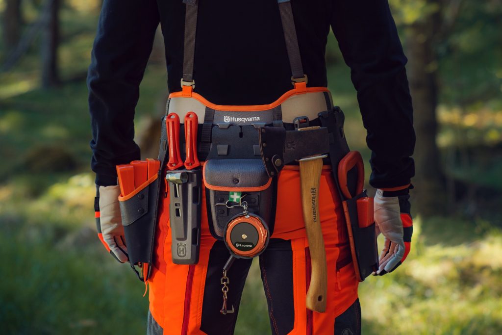 Logger belt with axe, wedges, files, measuring tape, lifting hooks and tongs, and first aid kit